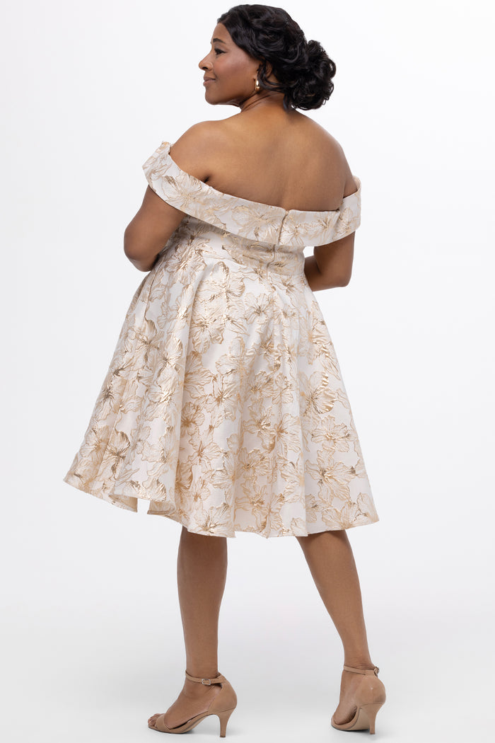 Celebrations by Sydney's Closet CE2610 in Gold Floral. 

Plus size knee-length party dress in metallic gold floral brocde print. Off-the-shoulder neckline, natural waistline and A-line skirt with pockets.