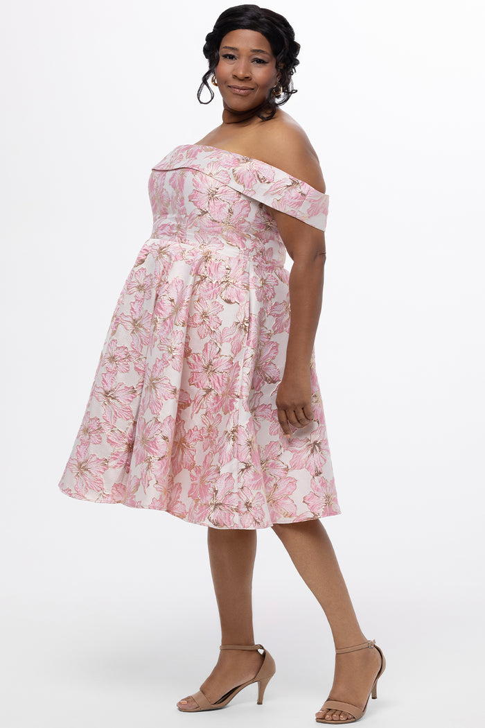 Celebrations by Sydney's Closet CE2610 in Light Pink Floral. 

Plus size knee-length party dress in metallic light pink floral brocde print. Off-the-shoulder neckline, natural waistline and A-line skirt with pockets.