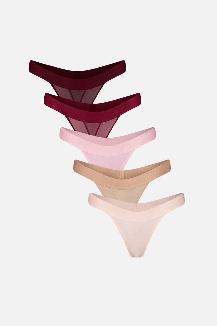 Five pairs of sheer mesh thongs in different shades, arranged in a cascading stack on a light gray background.