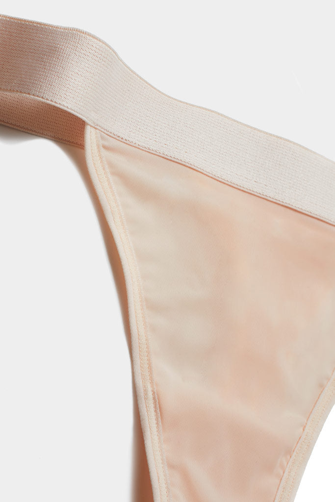 Peach silky thong with smooth fabric and thin elastic waistband