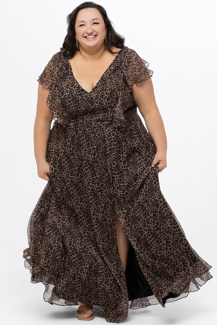 Celebrations by Sydney's Closet style CE2606 in animal print. 

Long plus size animal print dress.  V-neck, short flutter sleeves, natural waistline, pockets and ruffles on bodice princess seams. Left leg slit. Made from printed chiffon and light satin lining. High scoop back and center back zipper.