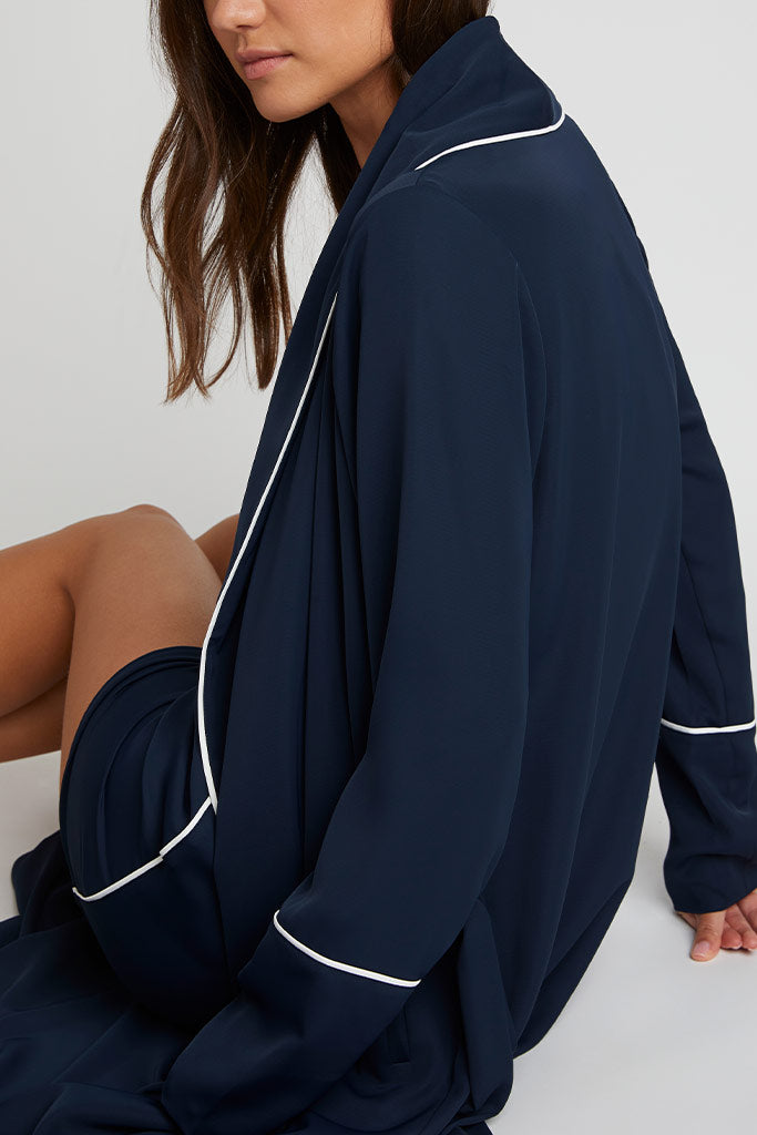 Navy robe with white piping, long sleeves, and open front drape