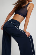 Navy track pants with elastic waist, wide leg, and white vertical side stripe