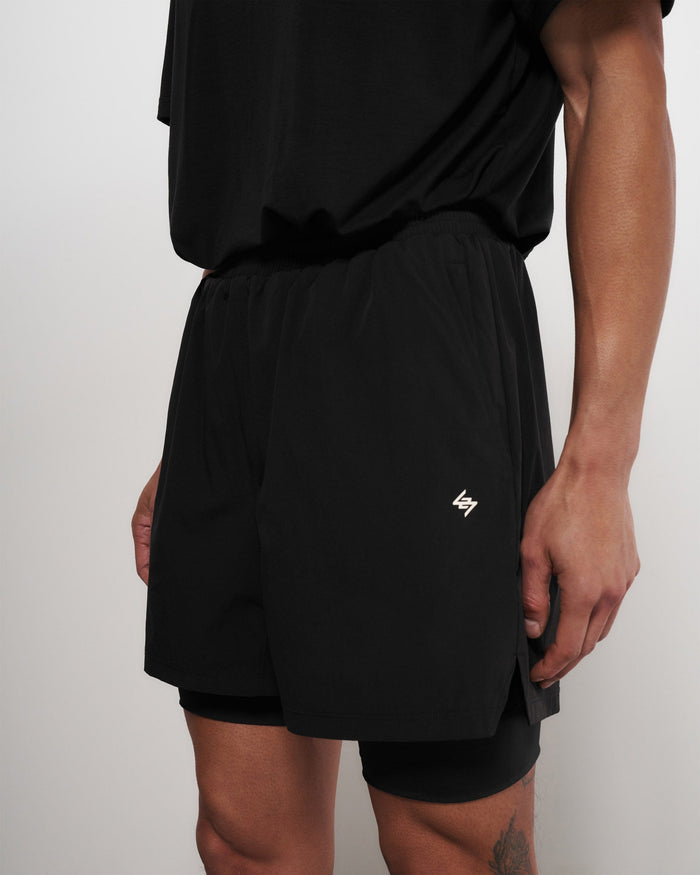 Man wearing black performance shorts on a plain white background | Team 247 2-In-1 Shorts in Black | Shorts with inside leggings and zip pockets | 247 Shorts | Represent Clo