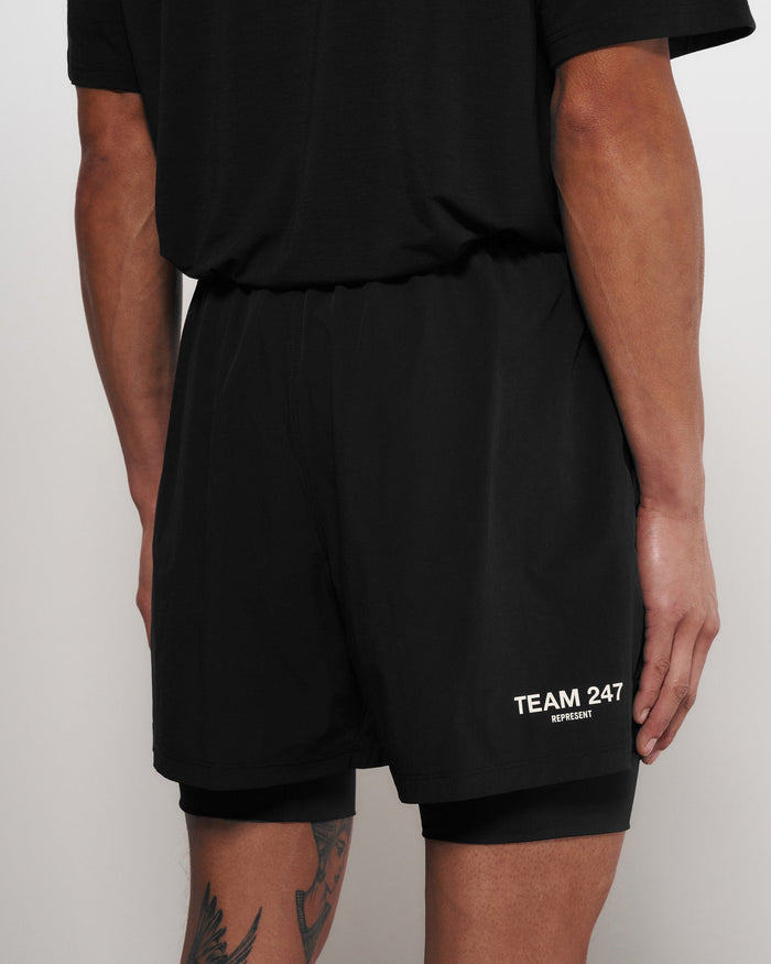 Man wearing black 2-in-1 shorts on a plain white background | Team 247 2-In-1 Shorts in Black | Shorts with inside leggings and elasticated waistband | 247 Shorts | Represent Clo