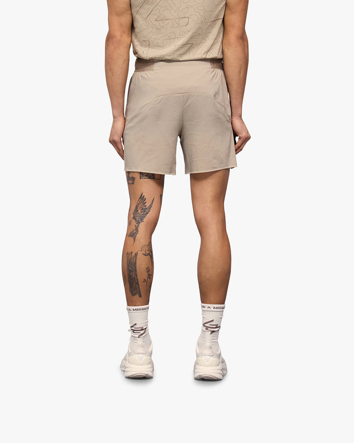 Man wearing grey shorts on a plain white background | Team 247 Aero Shorts in Pebble | Lightweight breathable running shorts | 247 Shorts | Represent Clo
