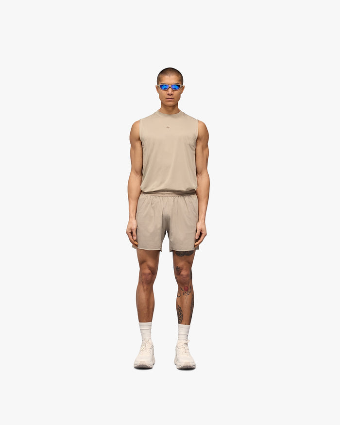 Man wearing grey shorts on a plain white background | Team 247 Aero Shorts in Pebble | Lightweight shorts with branded waistband and zip pockets | 247 Shorts | Represent Clo