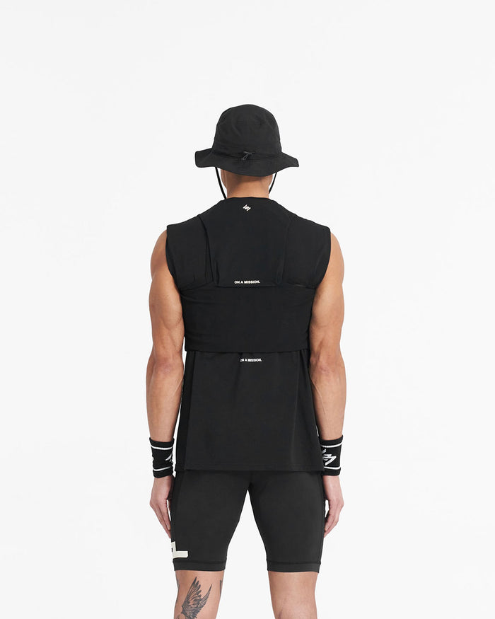 Man wearing a black chest rig on a plain white background | Team 247 Chest Rig in Black | Workout accessory with magnetic buckles and multiple pockets | 247 Accessories | Represent Clo