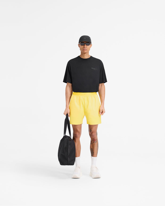 Man wearing yellow gym shorts on a plain white background | Team 247 Fused Shorts in Lemon | Shorts with reverse coil zippers and 4 way stretch | 247 Shorts | Represent Clo