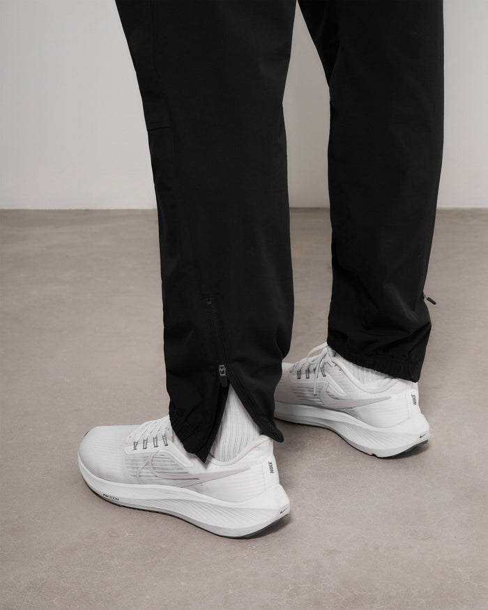 Man wearing black training pants on a plain white background | Team 247 Training Pant in Black | Training pant with elasticated waistband and zip pockets | 247 Pants | Represent Clo