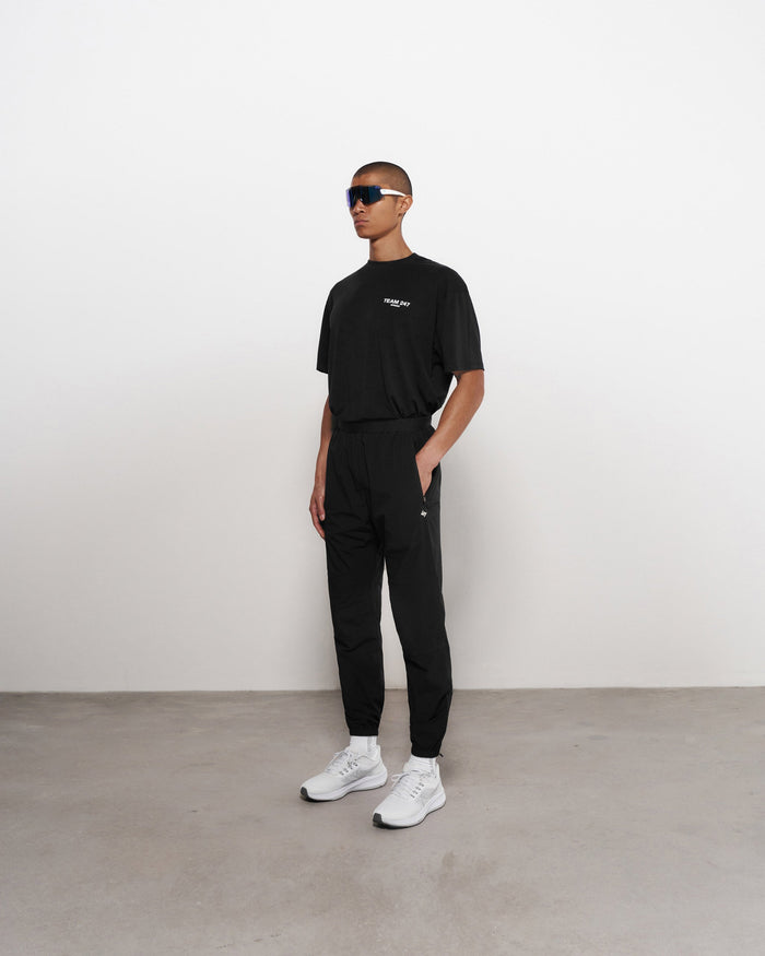 Man wearing black training pants on a plain white background | Team 247 Training Pant in Black | Training pants with elastic waistband and zip cuffs | 247 Pants | Represent Clo
