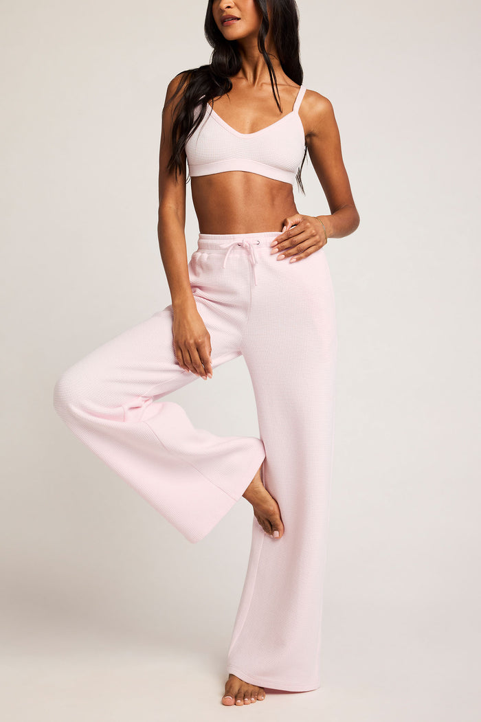 Waffle knit track pants in light pink, wide-leg with elastic drawstring waistband.