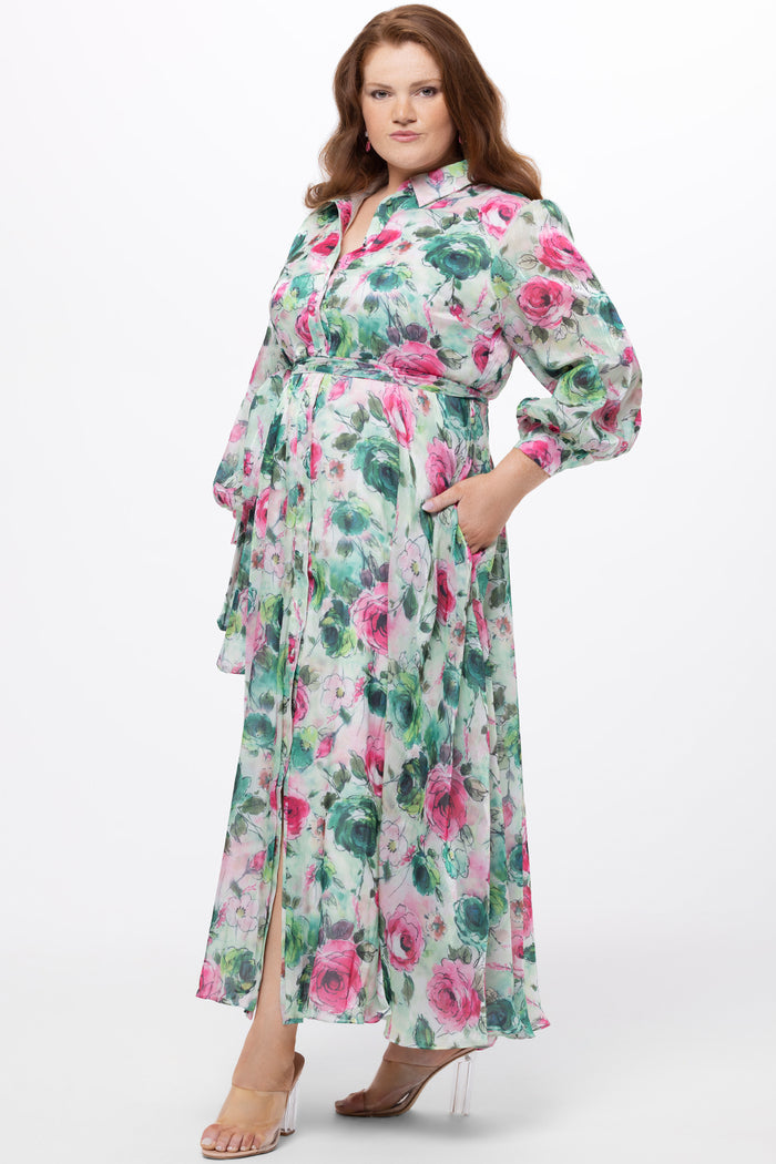Celebration's by Sydney's Closet style CE2621 in floral. 

Button down plus size ankle length floral gown made from printed organza. V-neck, long pouf sleeves with cuff and optional belt. A-line skirt with pockets.