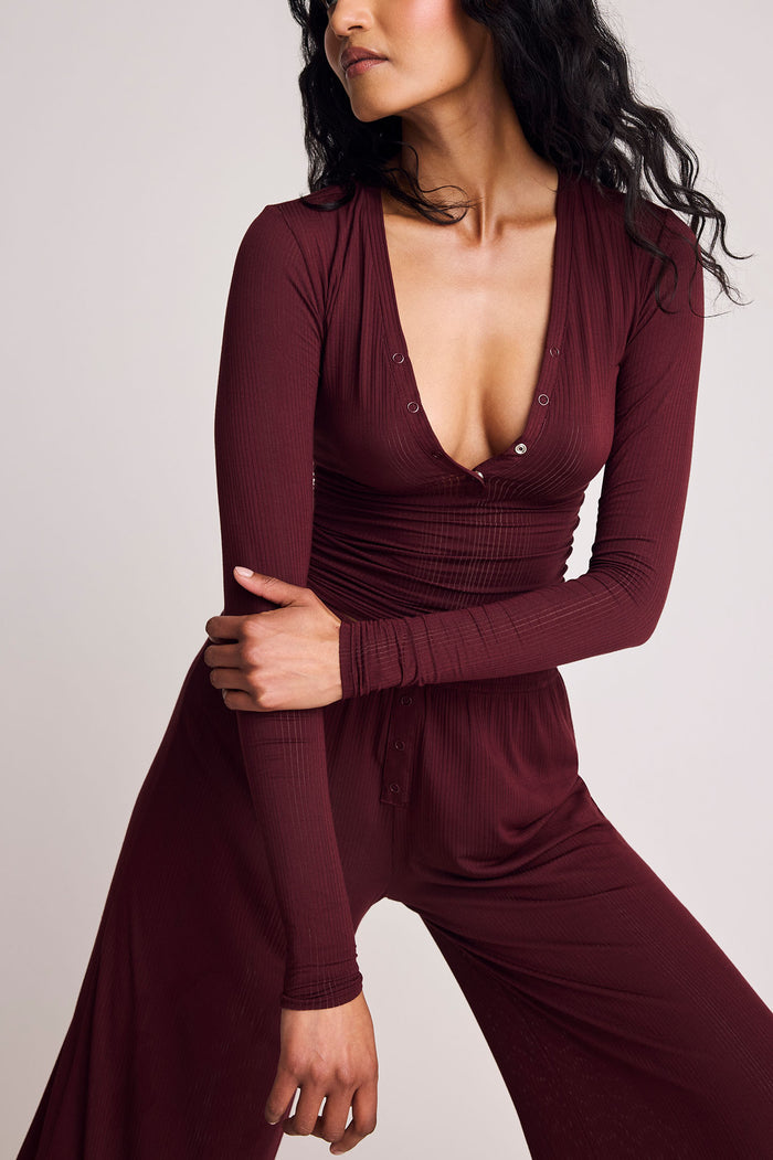 Garnet long-sleeve henley top with V-neck and button placket, ruched waist
