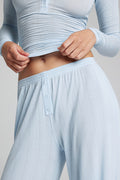 Light blue track pants waistband with front button placket and gathered elastic
