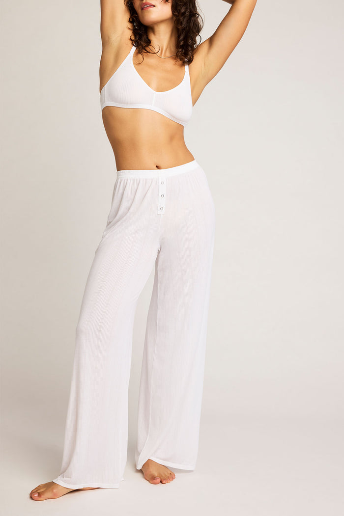 White track pants with elastic waist, wide-leg silhouette and button front detail